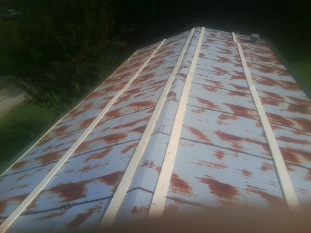 Rusted metal roof panels with new wood purlins before replacement — Storm Damage Roof Repair in Navarre by Roofing Brothers