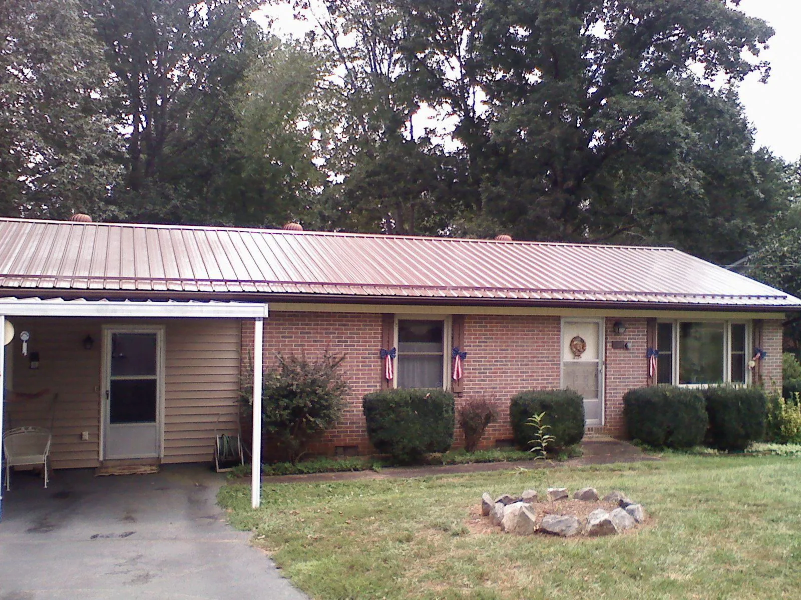 Bronze metal roof and carport on a brick ranch home — Roof Repair work by our crew in Navarre